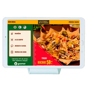 Tablet sobre a mesa do restaurante exibindo o cardápio digital integrado ao sistema